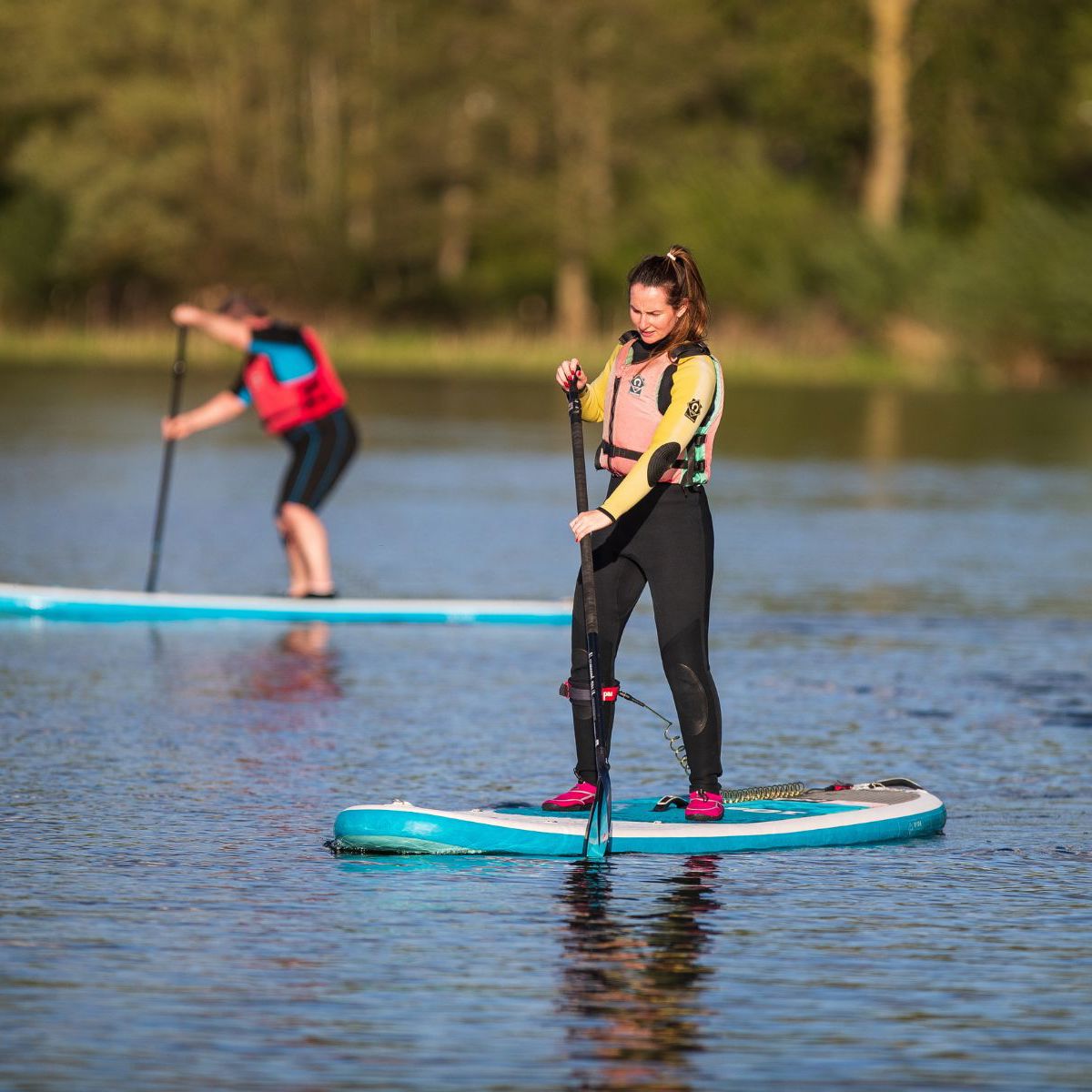 Person standing up on paddleboard on Willen Lake