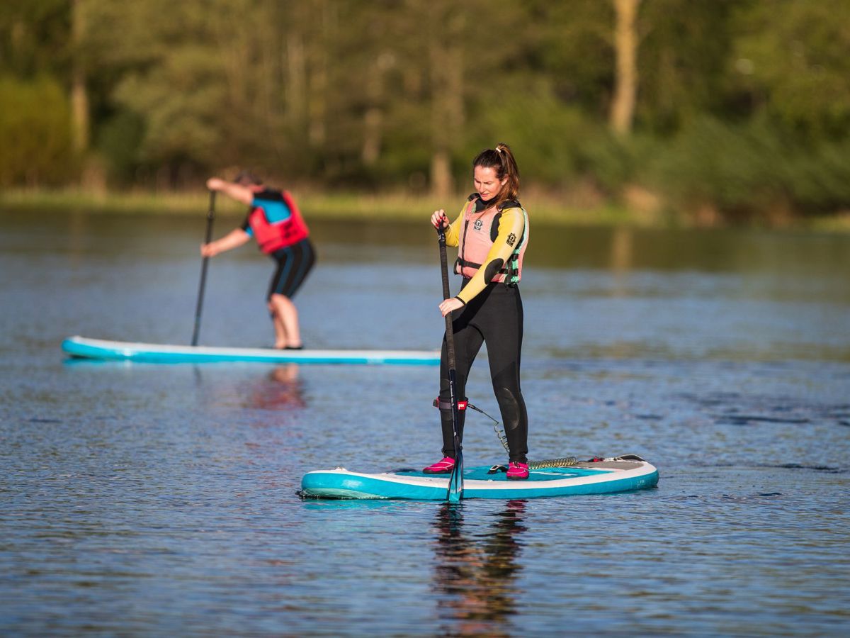 Person standing up on paddleboard on Willen Lake