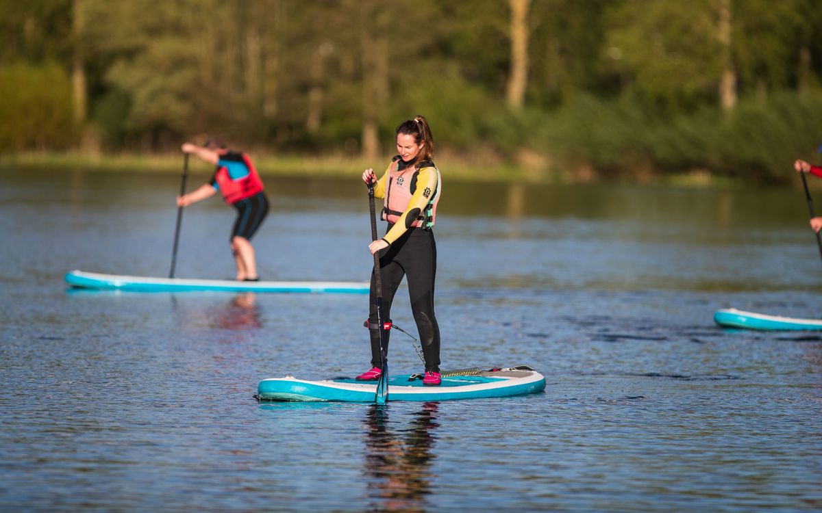 Person standing up on paddleboard on Willen Lake