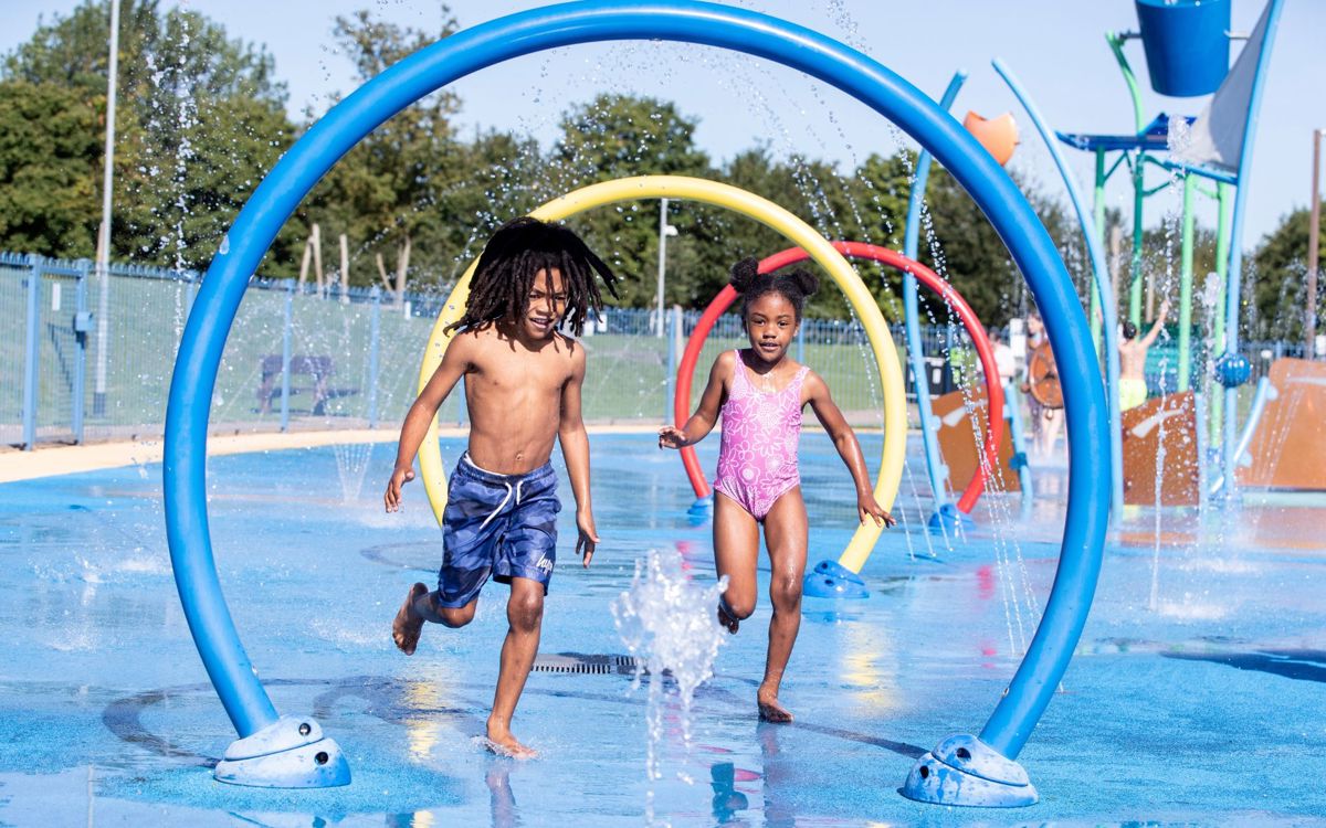 Two children running through water feature at Splash n Play in Milton Keynes