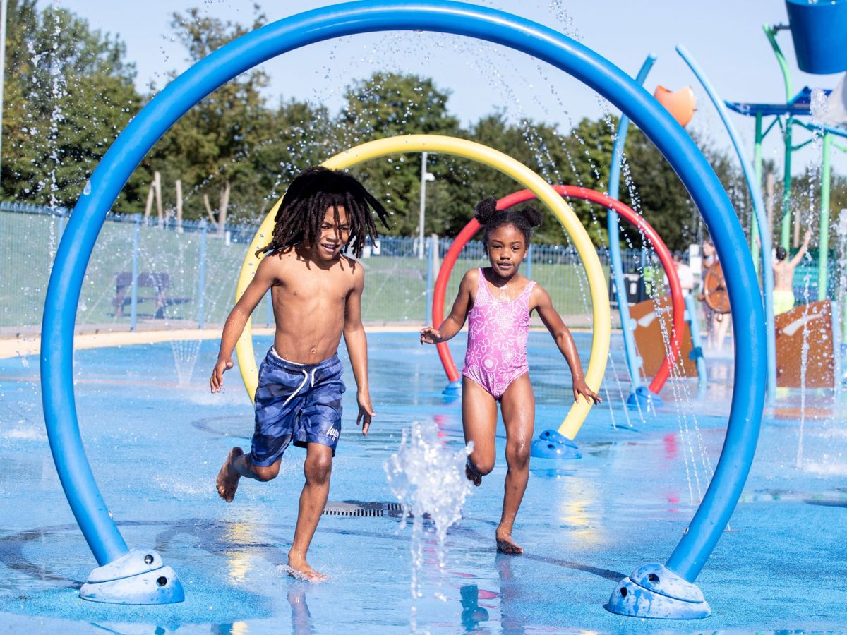 Two children running through water feature at Splash n Play in Milton Keynes