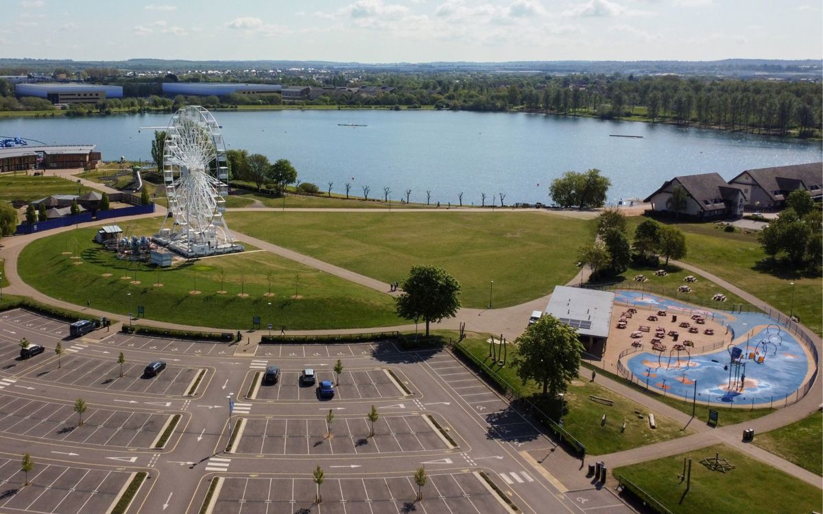Birds eye view of car park, observation wheel and the lake