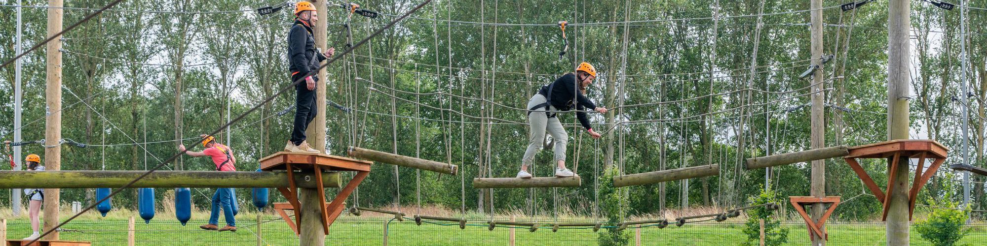 People balancing on Treetop Explorer high ropes course