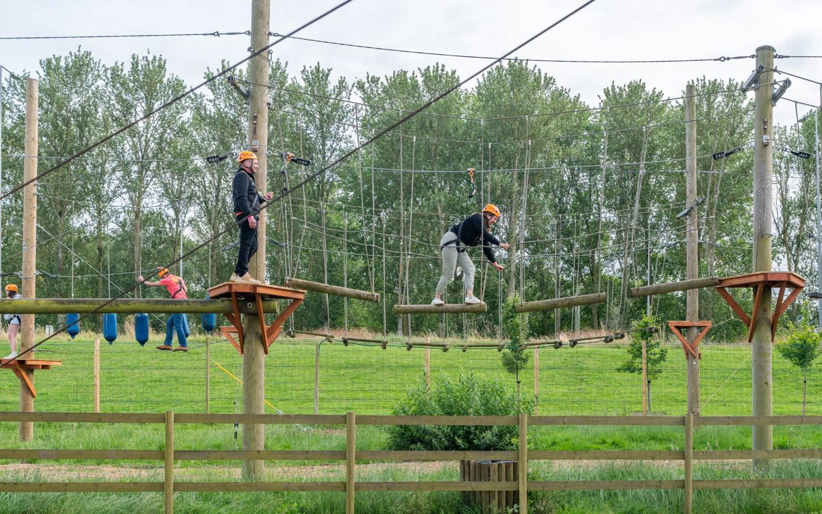 People balancing on Treetop Explorer high ropes course