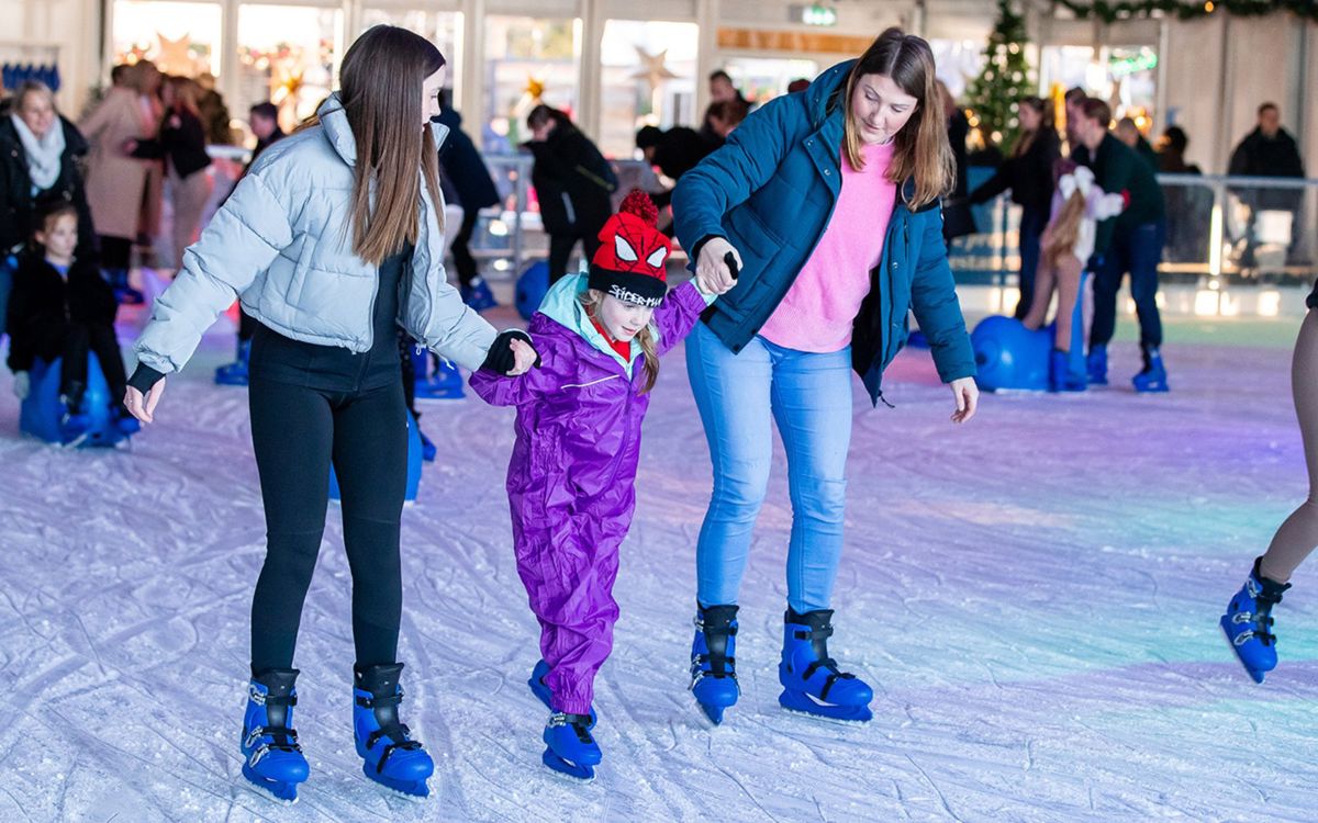 People helping each other to ice skate at Willen Lake