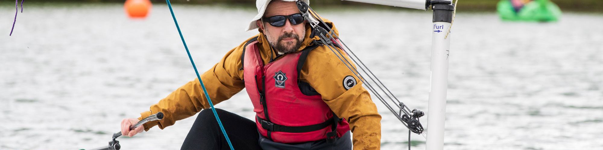 Person navigating sailing boat on a lake