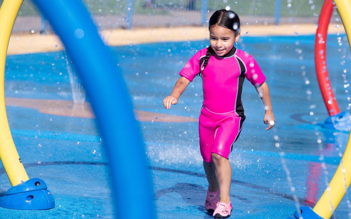 Child running through water feature