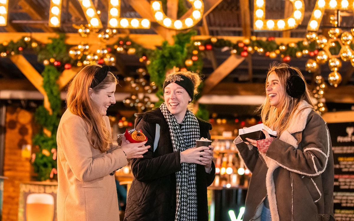 Ladies eating and laughing outside Apres Ski Bar at Willen On Ice