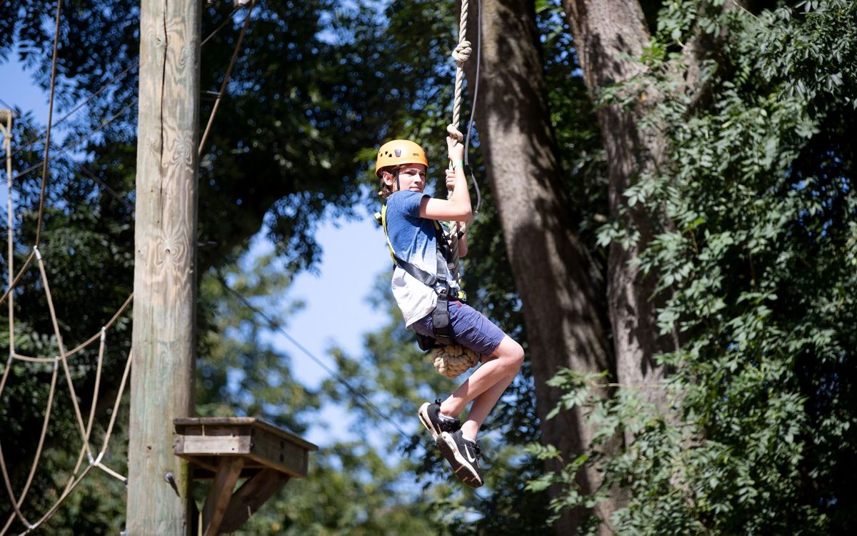 Child on zip wire on Treetop Adventure high ropes course at Willen Lake