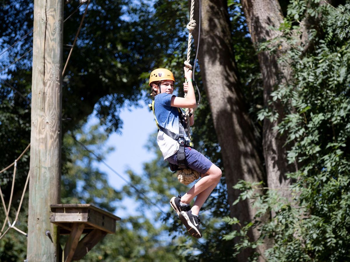 Child on zip wire on Treetop Adventure high ropes course at Willen Lake