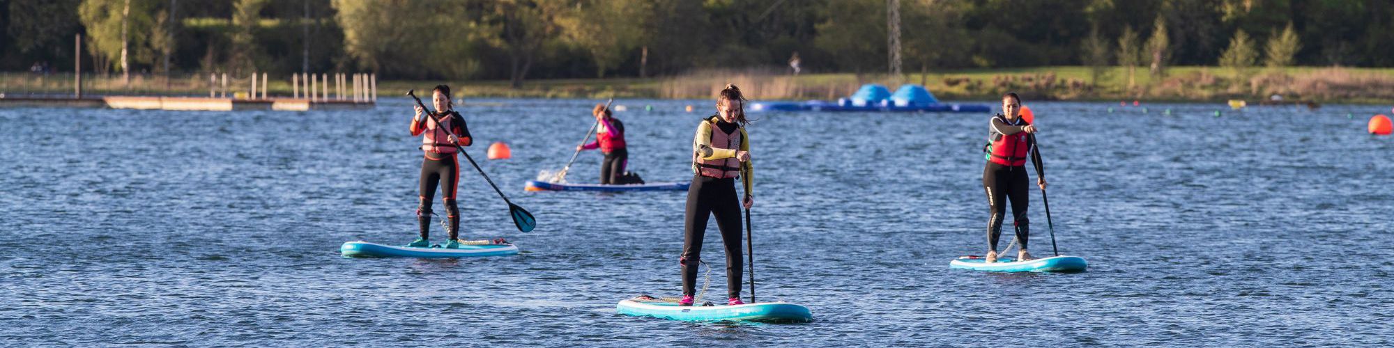 People standing on paddleboards on Willen Lake 