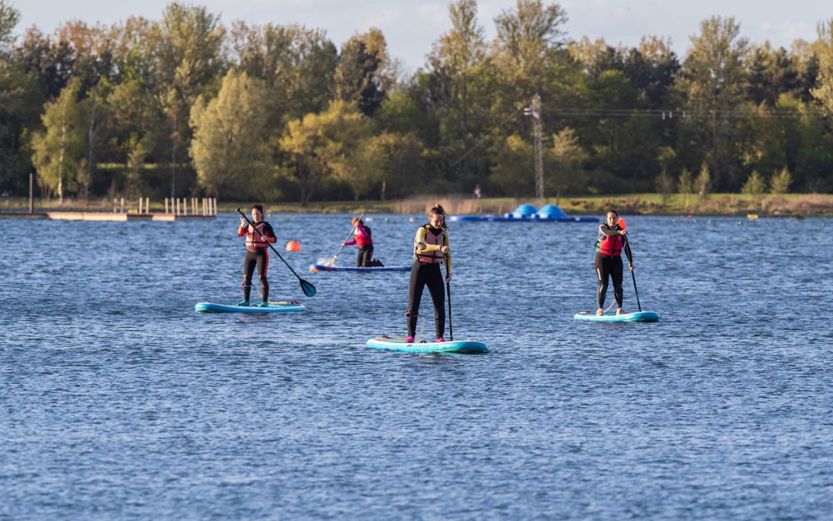 People standing on paddleboards on Willen Lake
