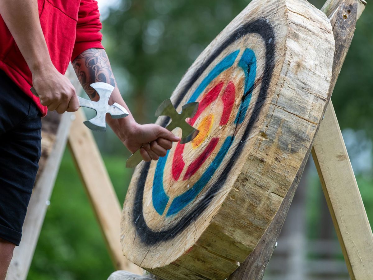 Person pulling axe from wooden target