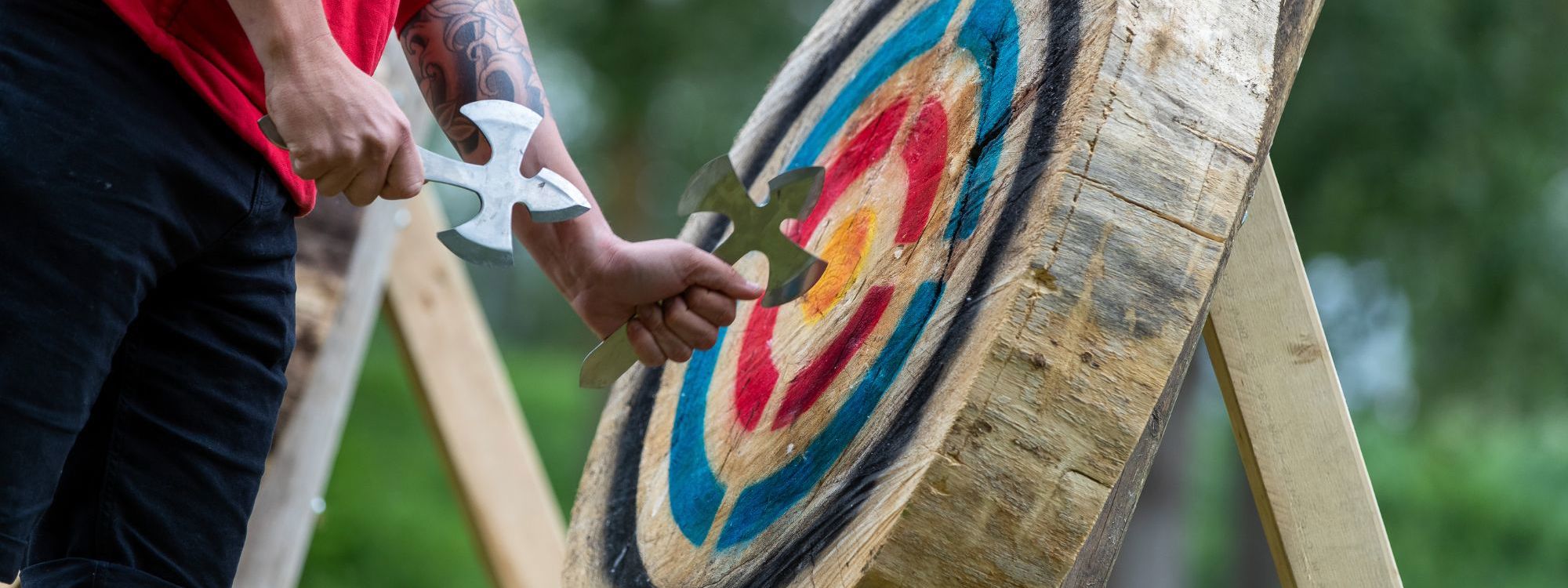Person pulling axe from wooden target