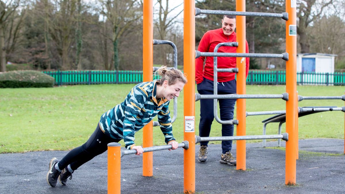Person doing push ups on outdoor gym equipment at Willen Lake