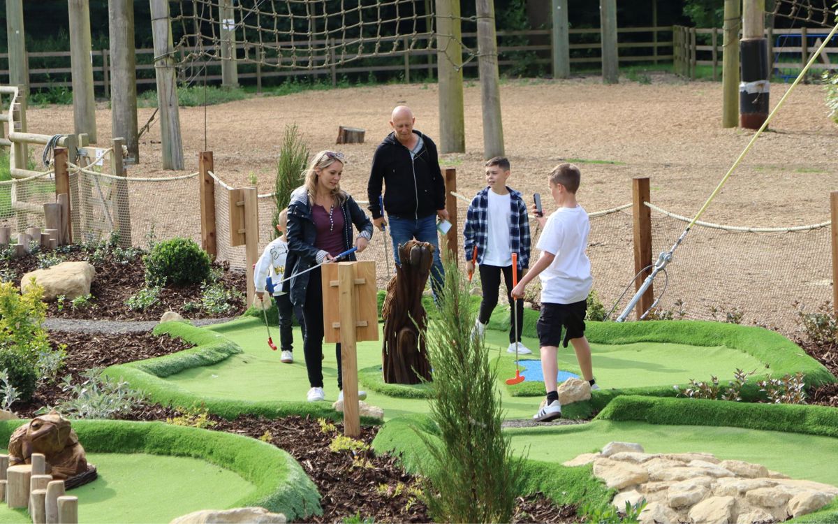 Family walking to the next hole on the Adventure Golf course